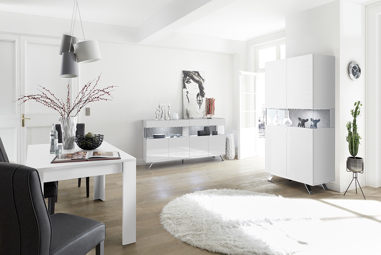 Sala moderna completa con tavolo bianco, madia e vetrina con piedini in ferro e interni biachi opachi