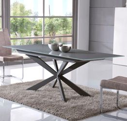 Tavolo di design allungabile con piano in vetro grigio e gambe in metallo