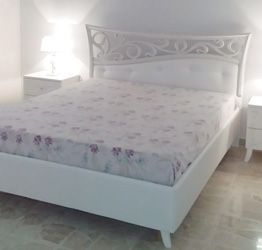 ACQUISTA ANCHE TU Letto matrimoniale con fregio in legno e imbottitura in ecopelle