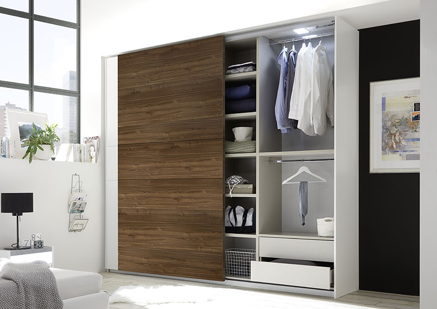 Camera matrimoniale con letto in ecopelle tabacco, armadio con anta noce dark e comodini bianchi opachi