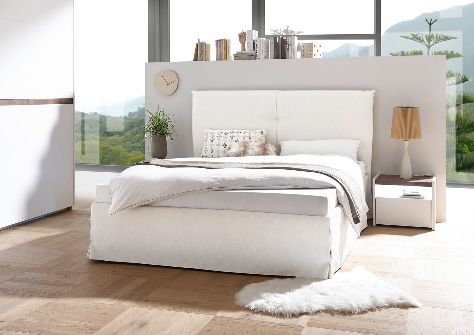 Camera matrimoniale con letto in ecopelle bianco, armadio con fascia beton e comodini bianchi opachi