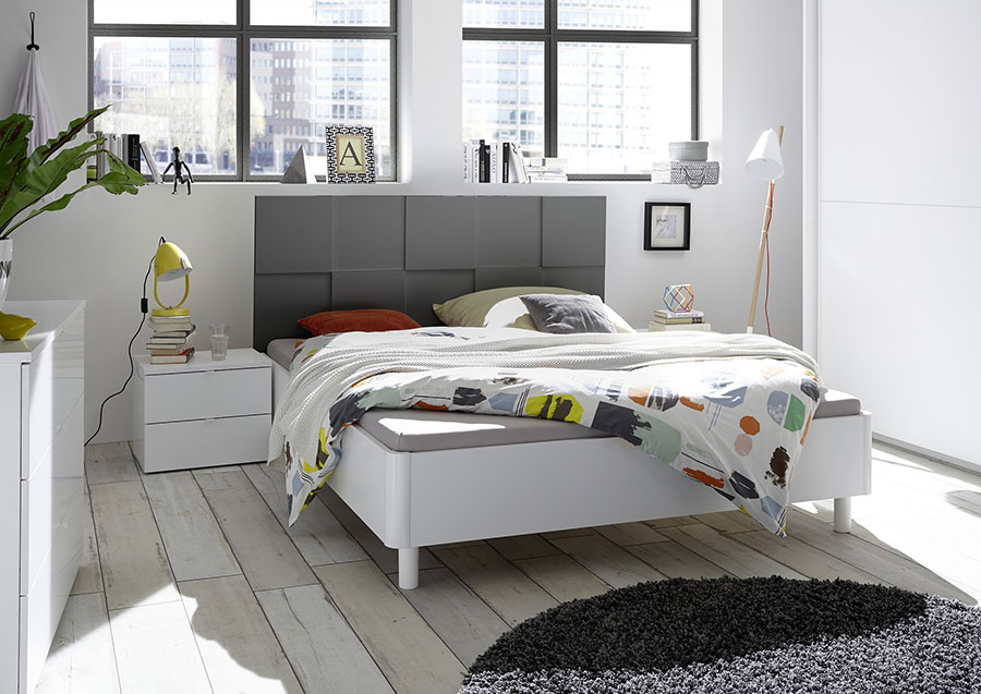 Letto bianco opaco con testiera grigio con forme geometriche 