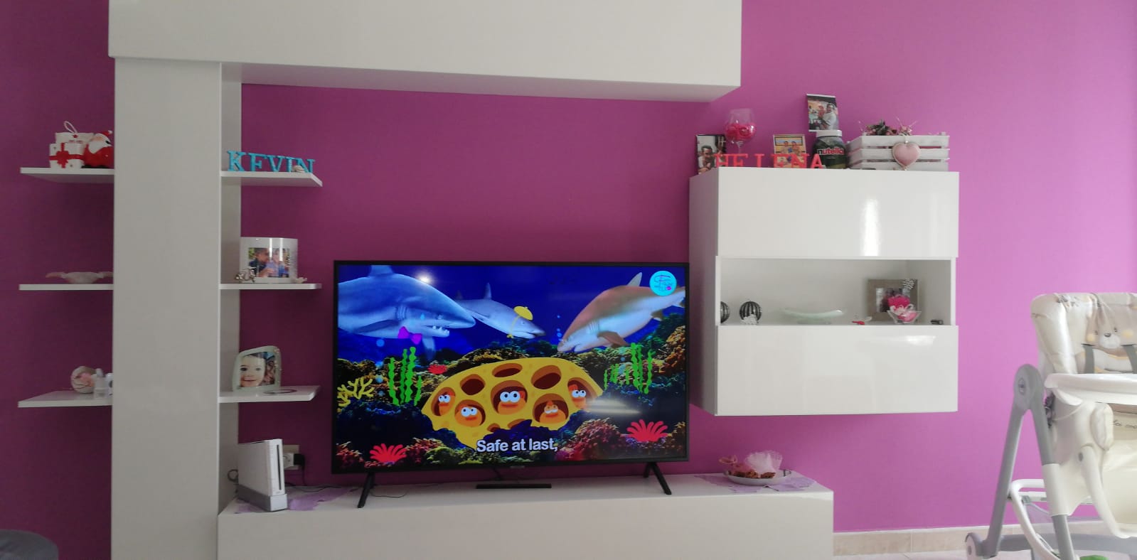 Parete attrezzata bianca con mensole, pensili e vano a giorno