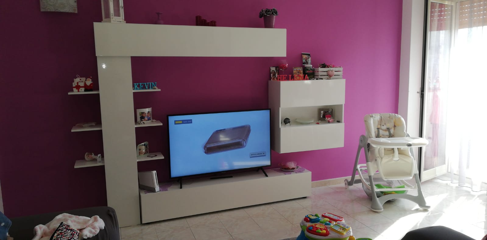 Parete attrezzata bianca con mensole, pensili e vano a giorno