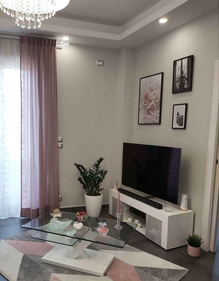 Porta tv grigio cemento e bianco, con due ante e ripiano centrale